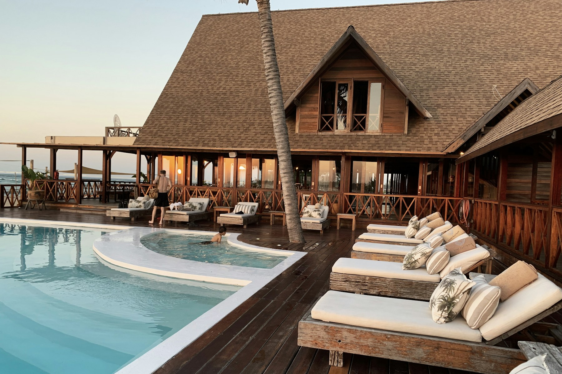 Sunlit hotel pool surrounded by palms